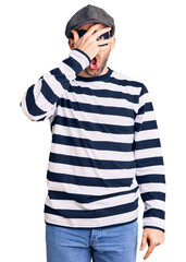 Sticker - Young handsome man wearing burglar mask peeking in shock covering face and eyes with hand, looking through fingers with embarrassed expression.