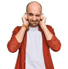 Sticker - Young hispanic man wearing casual clothes covering ears with fingers with annoyed expression for the noise of loud music. deaf concept.