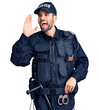 © Krakenimages.com - Young handsome man with beard wearing police uniform shouting and screaming loud to side with hand on mouth. communication concept.