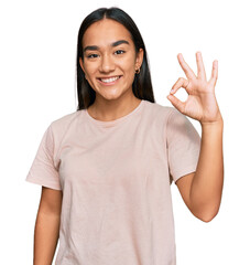 Wall Mural - Young asian woman wearing casual clothes smiling positive doing ok sign with hand and fingers. successful expression.