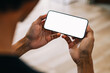 Mockup image of a man holding mobile phone with white blank screen for advertisement.