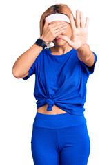 Poster - Young blonde woman wearing sportswear covering eyes with hands and doing stop gesture with sad and fear expression. embarrassed and negative concept.