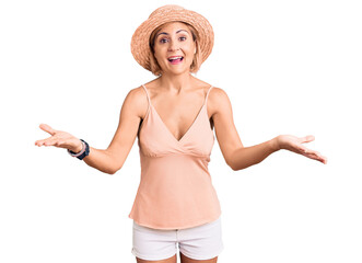 Wall Mural - Young blonde woman wearing summer hat smiling cheerful offering hands giving assistance and acceptance.