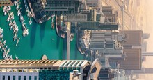 Vertical Timelapse Of Futuristic Dubai Marina And Yacht Club At Jumeirah Beach. Skyscrapers And Luxury Yachts On Pier In Man Made Lake In UAE. Famous Tourist View Of City Center And Desert Road.