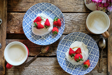 Sticker - Pavlova cake with strawberry on a white plate and a blue plate