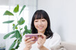 © Paylessimages - スマホで動画を見ている女性