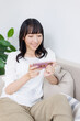 © Paylessimages - スマホで動画を見ている女性