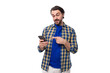 © Ivan Traimak - a young Caucasian brutal man with an unshaven face dressed in a plaid shirt uses a mobile phone