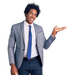 Sticker - Handsome african american man with afro hair wearing business jacket smiling cheerful presenting and pointing with palm of hand looking at the camera.