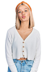 Canvas Print - Beautiful young blonde woman wearing casual white sweater looking at the camera blowing a kiss on air being lovely and sexy. love expression.