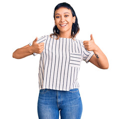 Wall Mural - Young woman wearing casual clothes success sign doing positive gesture with hand, thumbs up smiling and happy. cheerful expression and winner gesture.