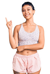 Canvas Print - Young woman wearing sportswear smiling happy pointing with hand and finger to the side