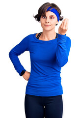 Sticker - Beautiful young woman with short hair wearing training workout clothes doing italian gesture with hand and fingers confident expression