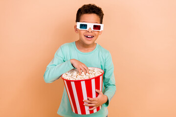 Wall Mural - Photo of funky cheerful boy enjoy new movie 3d glasses eat popcorn big box isolated on beige color background