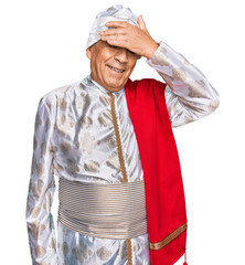 Poster - Senior hispanic man wearing tradition sherwani saree clothes smiling and laughing with hand on face covering eyes for surprise. blind concept.