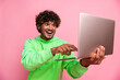 Photo of guy wearing green hoodie click keyboard looking at netbook display amazed bull bitcoin graphics isolated on pink color background