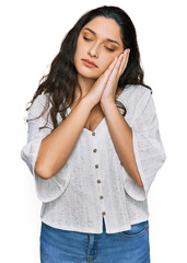 Wall Mural - Brunette young woman wearing casual clothes sleeping tired dreaming and posing with hands together while smiling with closed eyes.