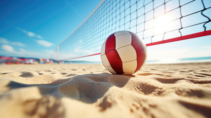 Close-up of white red beach volleyball on the sand of a sunny shore. Summer beach entertainment, fun activity on vacation.