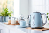 Fototapeta Natura - Electric blue kettle and tea or coffee cups on the table in a modern kitchen in light colors. Modern Tea set for quick preparation of hot drinks.