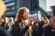 Woman shouting through megaphone on environmental protest in a crowd, big city. Fighting for environment, climate change, global warming.