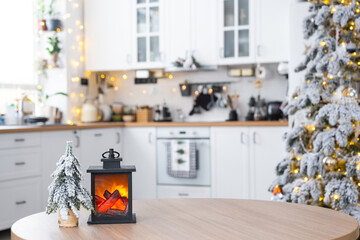 Wall Mural - Festive Christmas decor on a round empty table with space for text in white kitchen, modern interior with a Christmas tree and fairy lights. New Year, Christmas mood, cozy home. 