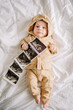 © Raivo - Portrait of a newborn boy with a photo of an ultrasound in the hand