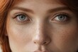 © liliyabatyrova - Close-up of the beautiful blue eyes of a red-haired woman with freckles. A direct look at the camera.