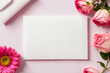White blank greeting card on a pink background with flowers, love letter