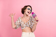 Portrait of positive overjoyed nice person hold microphone enjoy sing karaoke bar isolated on pink color background
