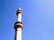A mosque minaret against clear blue sky
