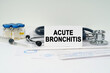 On the medical documents there is a stethoscope, syringe and a business card with the inscription - Acute bronchitis