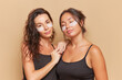 © South House Studio - Two brunette girls with cosmetic eyes patches on their faces pose over studio background, one girl closed her eyes, healthcare products concept, copy space