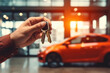Close up of a person holding car keys in modern auto salon. Car buying concept