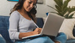 © Demencial Studies - Freelancer and student girl on the couch in her apartment using laptop