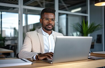 Wall Mural - Busy young business man looking at laptop at work. Focused young businessman company executive manager investor using computer sitting in office thinking of investment plan checking digital data