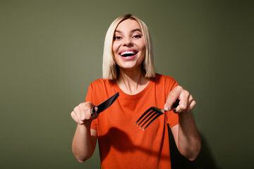 Wall Mural - Photo of funny hungry lady bob blonde hair hold metal fork knife wait handmade mommy meal cutting pieces isolated on khaki color background