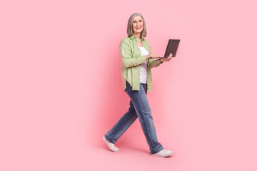 Canvas Print - Full length photo of positive successful pensioner woman dressed stylish clothes carry wireless netbook isolated on pink color background