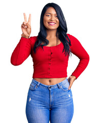 Poster - Hispanic woman with long hair wearing casual clothes smiling with happy face winking at the camera doing victory sign. number two.