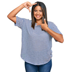 Canvas Print - Young latin girl wearing casual clothes smiling making frame with hands and fingers with happy face. creativity and photography concept.