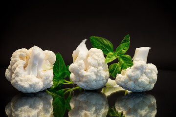 Canvas Print - slices of raw small raw cauliflower on black background