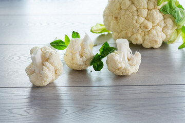 Canvas Print - slices of raw small raw cauliflower on wooden table