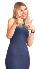 Wall Mural - Young beautiful blonde woman wearing casual dress pointing fingers to camera with happy and funny face. good energy and vibes.