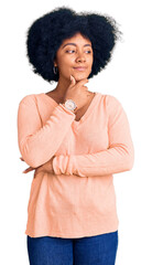 Poster - Young african american girl wearing casual clothes with hand on chin thinking about question, pensive expression. smiling with thoughtful face. doubt concept.