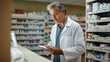 © tilialucida - A man in a white lab coat is looking at a tablet.