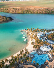 Aerial View Of Small Boats Along A White Sand Beach With A Luxury Resort Along The Coast, Grand Port, Mauritius.