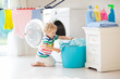 © famveldman - Child in laundry room with washing machine