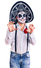 Poster - Man wearing day of the dead costume over background smiling funny doing claw gesture as cat, aggressive and sexy expression