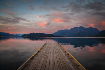 Sunset with Long Pier Leading Out into Water.  Harrison Lake, BC, Canada area is breathtaking with beautiful coves, beaches and islands, waterfalls, coniferous forests and snow-capped mountains.