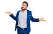 © Krakenimages.com - Young hispanic man wearing business jacket clueless and confused expression with arms and hands raised. doubt concept.