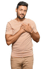 Sticker - Handsome hispanic man wearing casual clothes smiling with hands on chest with closed eyes and grateful gesture on face. health concept.